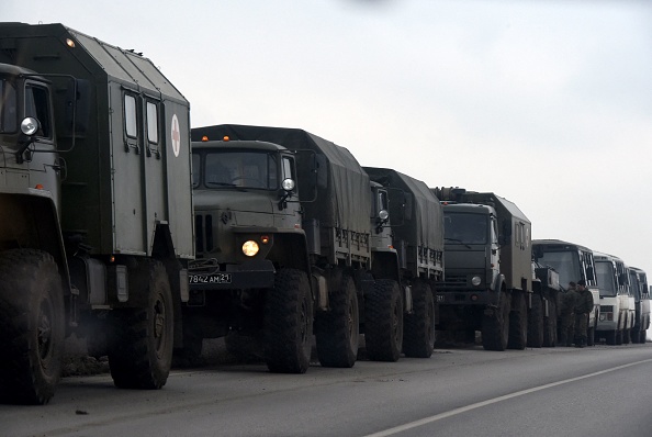 -Des camions et des bus militaires russes sont vus sur le bord d'une route dans la région de Rostov, au sud de la Russie, en bordure de Donetsk, le 23 février 2022. Photo de STRINGER/AFP via Getty Images.
