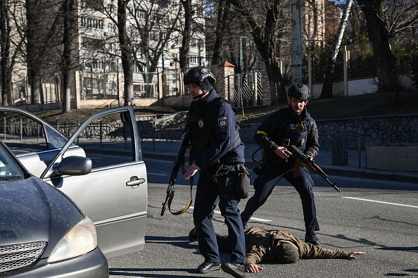 Des policiers ukrainiens arrêtent des voitures à la recherche d'hommes suspects, le 27 février 2022 dans une rue de Kiev. Photo par ARIS MESSINIS/AFP via Getty Images.