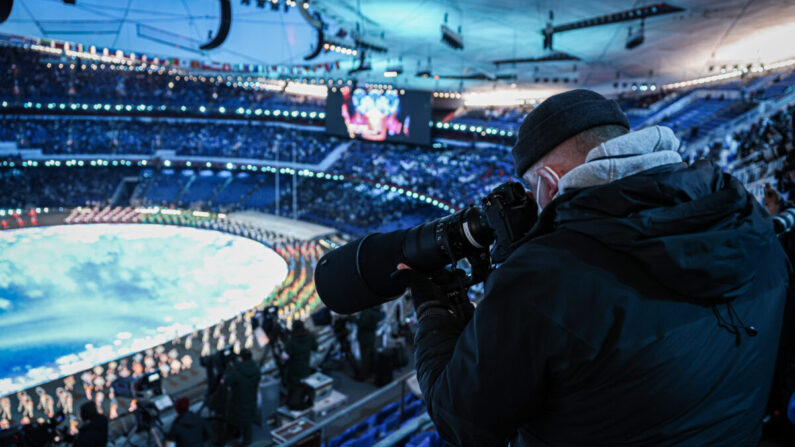 Un journaliste prend une photo du spectacle précédant la cérémonie des Jeux olympiques d'hiver de 2022, le 4 février 2022 à Pékin, en Chine. (Annice Lyn/Getty Images)