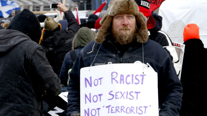 Un manifestant tient une pancarte sur la rue Wellington à Ottawa, le 12 février 2022. (Noé Chartier/The Epoch Times)