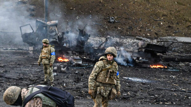 Des soldats ukrainiens cherchent et ramassent des obus qui n'ont pas explosé après avoir combattu un groupe d'assaillants russes dans la capitale ukrainienne, Kiev, au matin du 26 février 2022. (Sergei Supinsky/AFP via Getty Images)