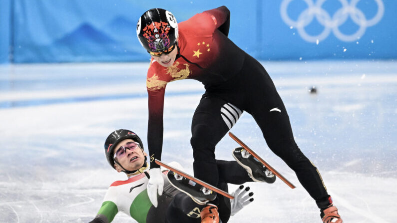 Le Hongrois Shaolin Sandor Liu (à gauche) tombe à côté du Chinois Ren Ziwei après avoir franchi la ligne d'arrivée lors de la finale A de l'épreuve masculine de patinage de vitesse sur piste courte de 1000 m, lors des Jeux olympiques d'hiver de Pékin 2022, au stade couvert de la capitale, à Pékin, le 7 février 2022. (Anne-Christine Poujoulat/AFP via Getty Images)