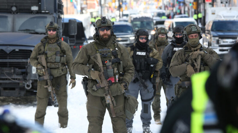 Des policiers armés se déploient pour éloigner les manifestants qui protestent contre les mandats Covid-19, à Ottawa, le 18 février 2022. (Dave Chan/AFP via Getty Images)