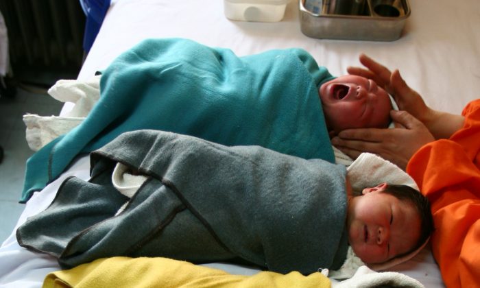 Une infirmière réconforte un bébé à l'hôpital pour enfants de Xining, dans la ville de Xining,  province du Qinghai. Selon un reportage de la Radio nationale chinoise, les hôpitaux de la province du Henan ont fait de la publicité pour vendre des bébés non désirés. (Getty Images)