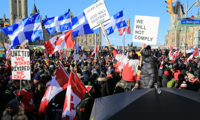 Des personnes se rassemblent sur la colline du Parlement canadien, alors que le convoi de camionneurs protestant contre les mandats et restrictions liés au Covid-19 organise des manifestations, à Ottawa, le 29 janvier 2022. (Jonathan Ren/The Epoch Times)
