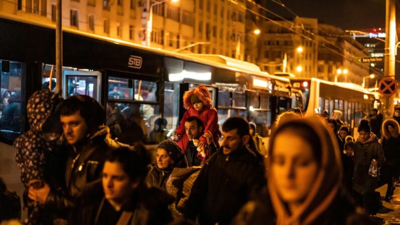 Des réfugiés venant d'Ukraine montent dans des bus après leur arrivée à Bucarest, en Roumanie, le 4 mars 2022. (Mihai Barbu/AFP via Getty Images)