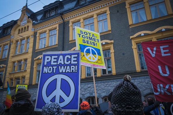 Des personnes manifestent contre l'invasion de l'Ukraine par la Russie devant l'ambassade de Russie à Helsinki, en Finlande, le 24 février 2022.