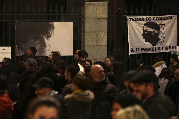 Des manifestants se rassemblent à côté d'un portrait d'Yvan Colonna devant la préfecture d'Ajaccio, le 4 mars 2022, après l'agression du militant indépendantiste à la prison d'Arles; (Photo : PASCAL POCHARD-CASABIANCA/AFP via Getty Images)
