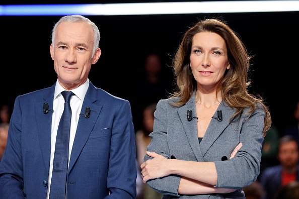Les journalistes et animateurs de télévision français Anne-Claire Coudray et Gilles Bouleau posent avant l'émission "La France face a la guerre" diffusée sur TF1 le 14 mars 2022.  (LUDOVIC MARIN/POOL/AFP via Getty Images)
