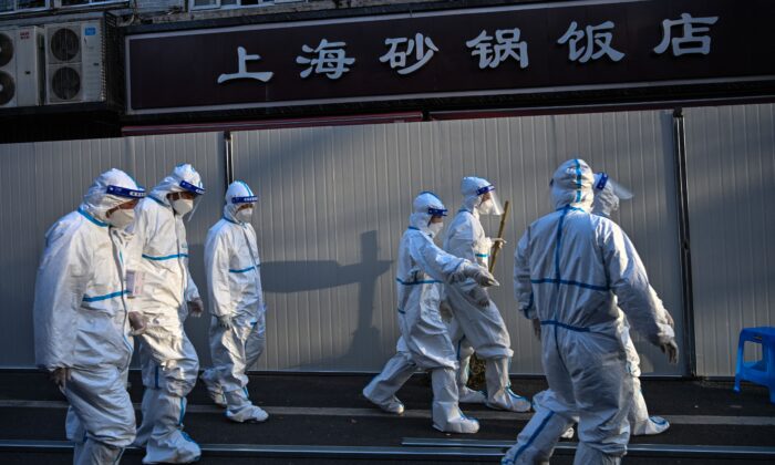Des ouvriers ferment les rues de certaines zones de confinement après la détection de nouveaux cas de Covid-19 à Shanghai, le 15 mars 2022. (Hector Retamal/AFP via Getty Images)