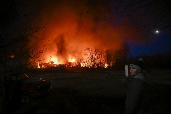  Un entrepôt en feu après un bombardement à Kiev le 17 mars 2022. Les forces russes ont également été accusées d'avoir bombardé un théâtre abritant de nombreux civils. Photo par Aris MESSINIS/AFP via Getty Images.