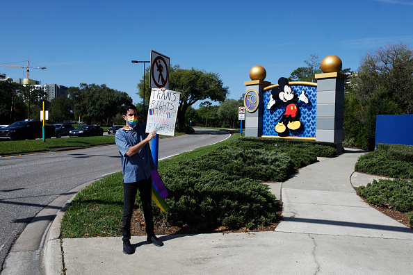 Un employé de Disney, tient une pancarte 'Don't Say Gay' devant Disney World, le 22 mars 2022 à Orlando, en Floride. (Photo by Octavio Jones/Getty Images)