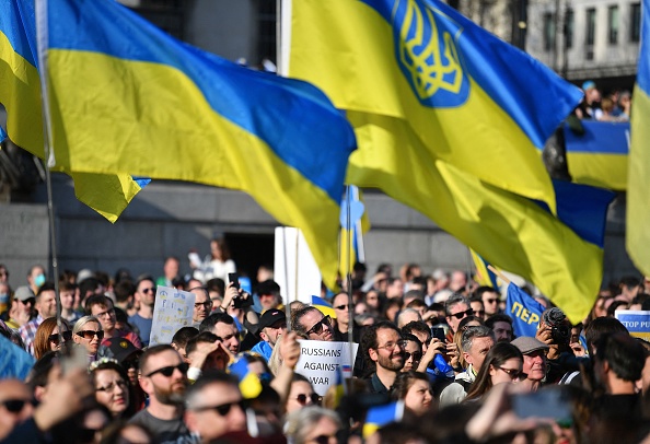 -Les gens tiennent des pancartes et des drapeaux nationaux ukrainiens à Trafalgar Square, lors d'une marche de protestation et d'une veillée "Londres se tient avec l'Ukraine", dans le centre de Londres le 26 mars 2022. Photo de JUSTIN TALLIS/AFP via Getty Images.