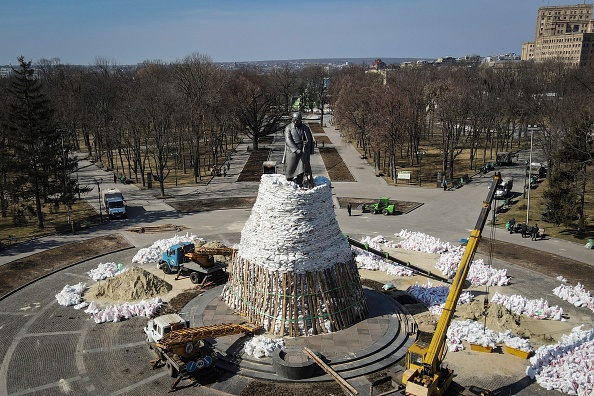 -Les employés municipaux couvrent les monuments de la ville avec des sacs de sable pour les protéger à Kharkiv le 26 mars 2022.  Photo par Aris MESSINIS/AFP via Getty Images.