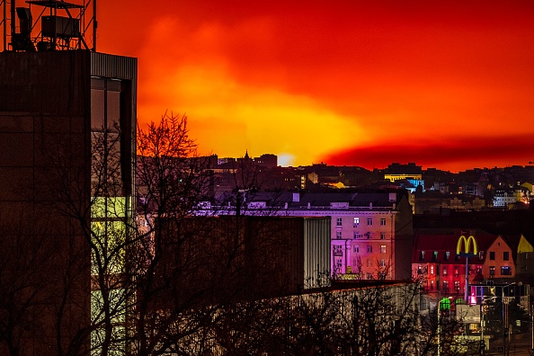 Du feu et de la fumée éclaire le ciel nocturne, à l'est de Kharkiv le 30 mars 2022.  Photo par FADEL SENNA/AFP via Getty Images.
