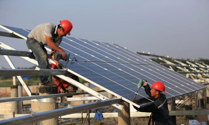 Des ouvriers installent des panneaux solaires sur le site de construction d'un projet d'énergie photovoltaïque en réseau de 40MW à Huai'an, en Chine, le 11 juin 2018. (VCG/VCG via Getty Images)
