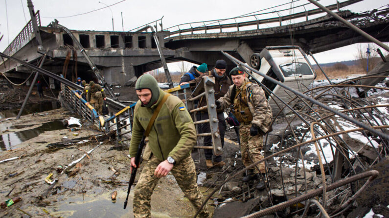 Des soldats ukrainiens traversent le pont détruit à Irpin, en Ukraine, le 1er mars 2022. (Anastasia Vlasova/Getty Images)