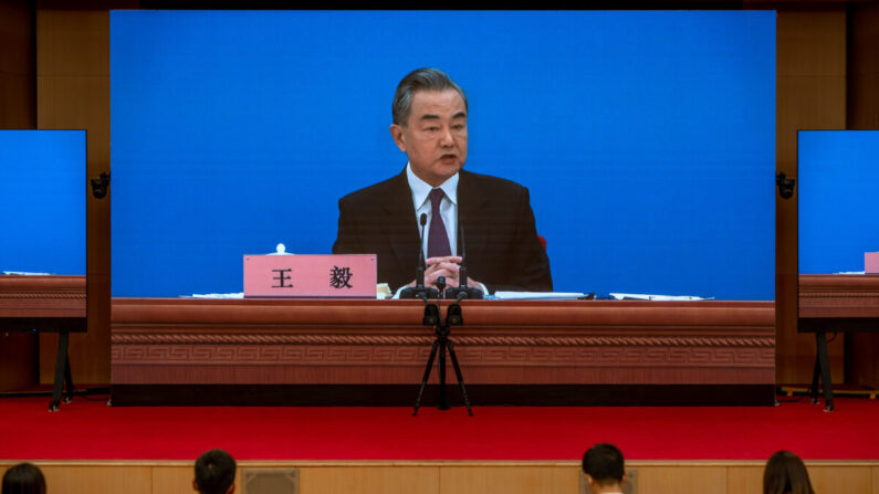 Le ministre chinois des Affaires étrangères, Wang Yi, apparaît sur de grands écrans alors qu'il tient une conférence de presse au Centre des médias à Pékin, le 7 mars 2022. (Andrea Verdelli/Getty Images)