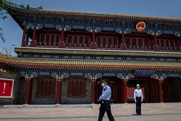 Un agent de sécurité (à dr.) et un policier (à g.) sécurisent la zone à l'entrée de Zhongnanhai, le quartier général et la résidence des autorités communistes chinoises à Pékin, le 18 mai 2020. (Photo de Nicolas Asfouri/AFP via Getty Images)