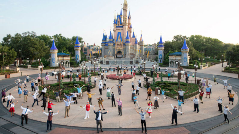 Des dirigeants de Disney et des membres de la distribution posent pour une photo devant le château de Cendrillon avant la réouverture du Parc Magic Kingdom à Disney World, le 11 juillet 2020, à Lake Buena Vista, en Floride. (David Roark/Walt Disney World Resort via Getty Images)