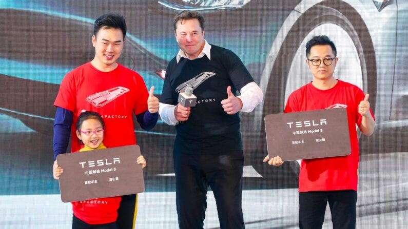 Le PDG de Tesla, Elon Musk, pose pour des photos avec des acheteurs lors de la cérémonie de livraison du Model 3 fabriqué en Chine, à Shanghai. (Photo par STR/AFP via Getty Images)
