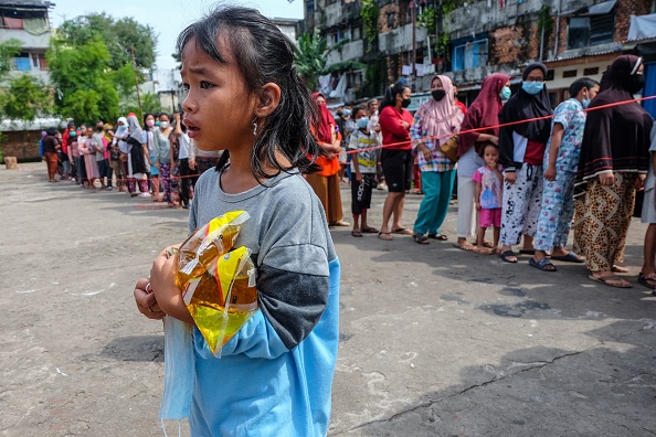 Les gens font la queue pour acheter de l'huile de cuisson à des prix abordables à Palembang le 24 février 2022. Photo par ABDUL QODIR / AFP via Getty Images.