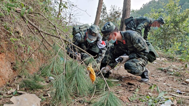 La police paramilitaire effectuant des recherches sur le site du crash de l'avion de China Eastern Airlines dans le comté de Tengxian, au sud de la Chine, le 21 mars 2022 (Photo par -/CNS/AFP via Getty Images)