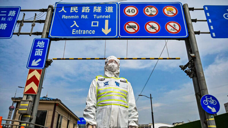 Un agent des transports en commun, portant un équipement de protection, contrôle l'accès à un tunnel en direction du quartier de Pudong à Shanghai, alors que la ville est dans une situation de confinement, le 28 mars 2022.(Hector Retamal/AFP via Getty Images)