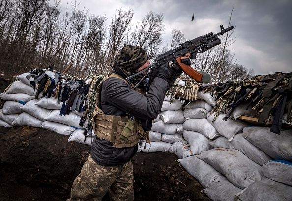 -Un militaire ukrainien tire sur un drone russe avec un fusil d'assaut depuis une tranchée sur la ligne de front à l'est de Kharkiv le 31 mars 2022. Photo de FADEL SENNA / AFP via Getty Images.