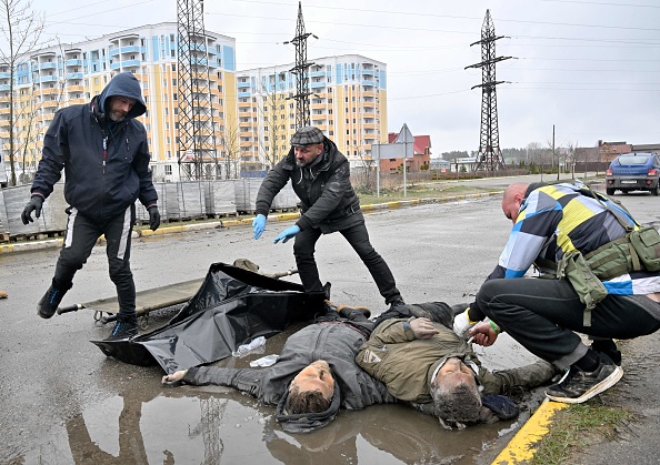 - Des employés communaux recueillent les corps de deux hommes dans la ville de Bucha, non loin de la capitale ukrainienne de Kiev, le 3 avril 2022. Photo de Sergei SUPINSKY / AFP via Getty Images.