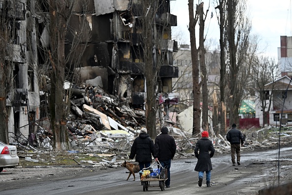 Des gens passent devant les bâtiments détruits dans la ville de Borodianka, au nord-ouest de Kiev, le 4 avril 2022. Photo Sergei SUPINSKY / AFP via Getty Images.
