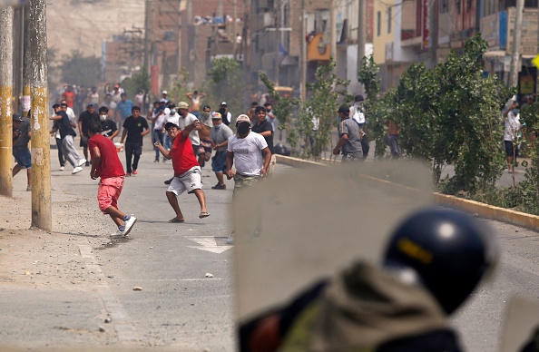 Des manifestants s'affrontent à la police anti-émeute lors d'une grève partielle des transporteurs de marchandises et de passagers, à Ate, un district à l'est de Lima, le 4 avril 2022. (Photo : GIAN MASKO/AFP via Getty Images)