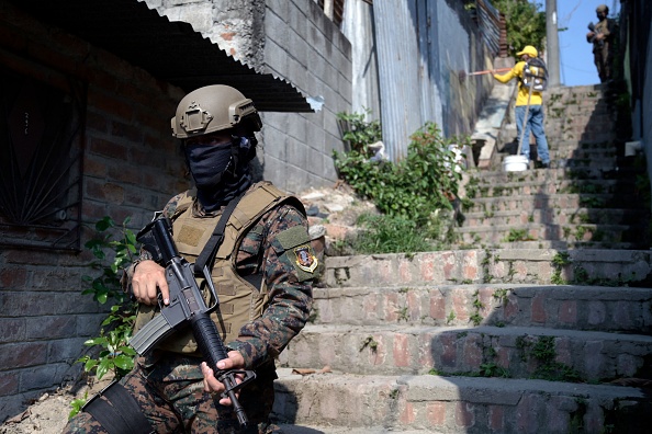 -Des détenus de la prison "La Esperanza", escortés par des gardiens et des soldats, suppriment des graffitis liés au gang dans la banlieue est de San Salvador le 7 avril 2022. Photo de MARVIN RECINOS/AFP via Getty Images.