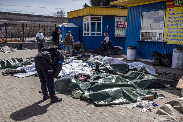 Des corps étendus sur le sol et recouverts d'une bâche après une attaque à la roquette qui a tué au moins 35 personnes le 8 avril 2022 dans la gare de Kramatorsk, dans l'est de l'Ukraine. Photo de FADEL SENNA/AFP via Getty Images.