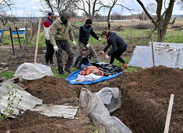 - L'épouse d'un civil est bouleversée devant son corps exhumé, d'une tombe peu profonde près de leur domicile dans le village d'Andriivka, région de Kiev, le 11 avril 2022. Photo de Sergei SUPINSKY / AFP via Getty Images.