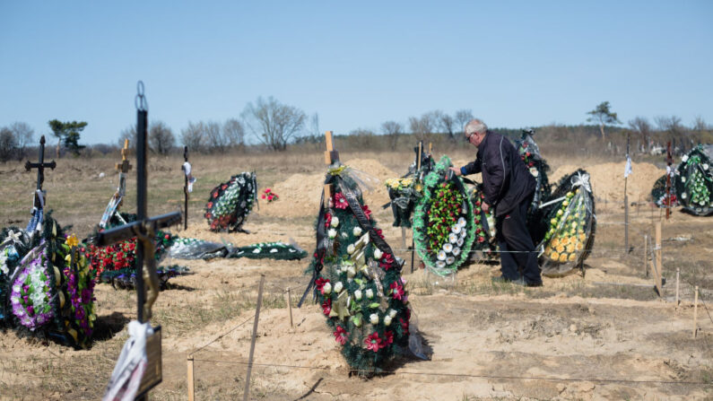Un homme fixe la couronne sur la tombe dans un cimetière le 14 avril 2022 à Hostomel, en Ukraine. La retraite russe des villes ukrainiennes a révélé des dizaines de morts civils et toute l'étendue de la dévastation de la tentative de la Russie de dominer le pays. (Photo par Anastasia Vlasova/Getty Images)