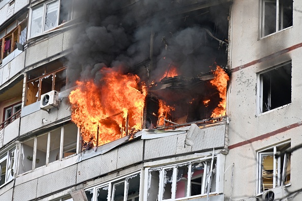 Des flammes sortent d'un appartement dans un immeuble résidentiel de la périphérie nord de Kharkiv à la suite d'un bombardement le 22 avril 2022. Photo de SERGEY BOBOK/AFP via Getty Images.