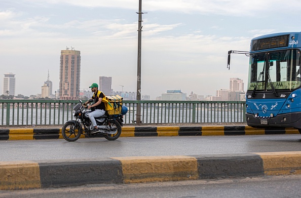Un livreur conduit sa moto dans la capitale égyptienne Le Caire le 21 avril 2022. Photo de Khaled DESOUKI / AFP via Getty Images.