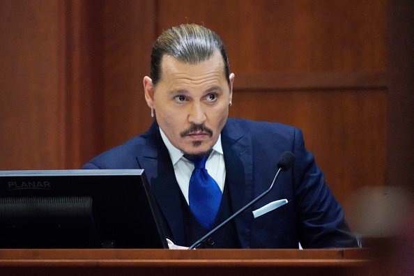 L’acteur Johnny Depp est assis pour témoigner dans la salle d'audience du palais de justice du comté de Fairfax  en Virginie, le 25 avril 2022. 
(Photo STEVE HELBER/POOL/AFP via Getty Images)