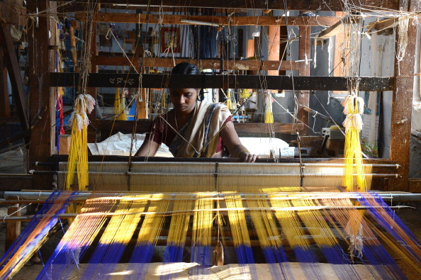 Andra Jyothi tisse un sari en soie sur un métier à main dans un atelier en Inde. Les saris en soie Pochampally sont réputés dans toute l'Inde pour leur tissage fin et leurs motifs dynamiques.  Photo /Noah SEELAM via Getty Images ?