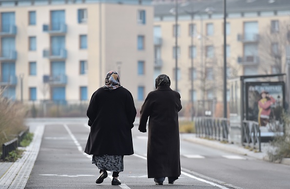 Deux femmes voilées marchent dans une rue de la banlieue de Strasbourg. (PATRICK HERTZOG/AFP via Getty Images)