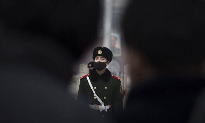 Des agents de police paramilitaire chinoise portant des masques pour se protéger de la pollution défilent dans le smog à la place Tiananmen de Pékin, le 9 décembre 2015. (Kevin Frayer/Getty Images)