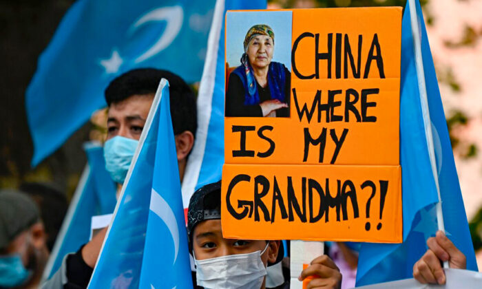 Un jeune militant ouïghour brandit une affiche sur laquelle on peut lire "Chine, où est ma grand-mère ?", lors d'une manifestation devant le ministère des Affaires étrangères à Berlin, où le ministre chinois des Affaires étrangères devait s'entretenir avec son homologue allemand, le 1er septembre 2020. (Tobias Schwarz/AFP via Getty Images)