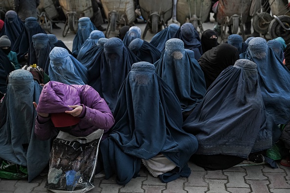 Des femmes portant une burqa attendent du pain gratuit devant une boulangerie à Kaboul le 24 janvier 2022. Photo by MOHD RASFAN/AFP via Getty Images.
