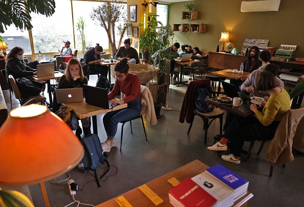 Les étudiants Libanais sont assis avec leurs ordinateurs portables dans un café à Beyrouth, un bon éclairage et une connexion Wi-Fi stable. Photo de JOSEPH EID/AFP via Getty Images.