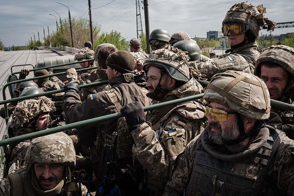 -Des soldats ukrainiens montent à l'arrière d'un camion vers un lieu de repos après avoir combattu sur la ligne de front pendant deux mois près de Kramatorsk, dans l'est de l'Ukraine, le 30 avril 2022. Photo de YASUYOSHI CHIBA/AFP via Getty Images.
