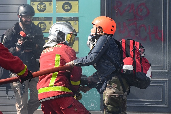 Le 1er mai 2022 à Paris, une manifestante a agressé un pompier pour l'empêcher d'éteindre un incendie, lui assénant deux coups avec la main sur son casque. (Photo by ALAIN JOCARD/AFP via Getty Images)