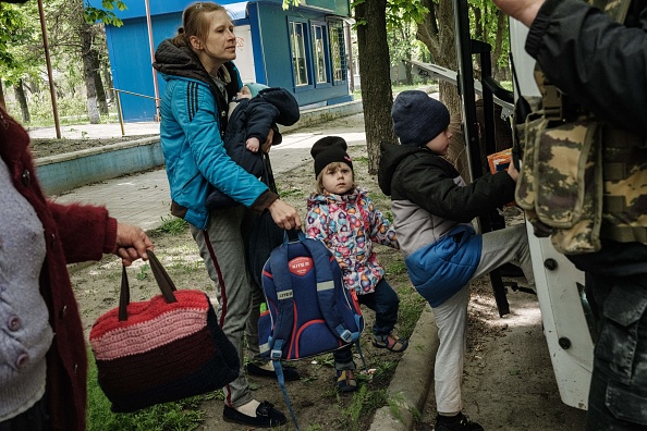 Nazar monte à bord d'un bus pare-balles pour évacuer avec sa famille la ville de Lyman, dans l'est de l'Ukraine, qui a reçu de lourds bombardements, le 2 mai 2022. Photo de YASUYOSHI CHIBA/AFP via Getty Images.