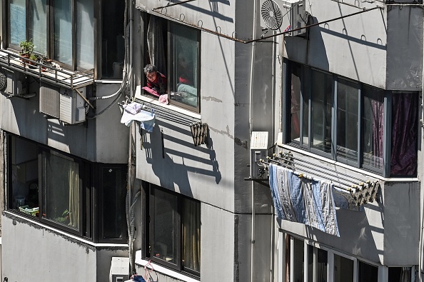 Un résident à sa fenêtre pendant le verrouillage Covid-19 dans le quartier de Jing'an à Shanghai, le 5 mai 2022. (Photo : HECTOR RETAMAL/AFP via Getty Images)