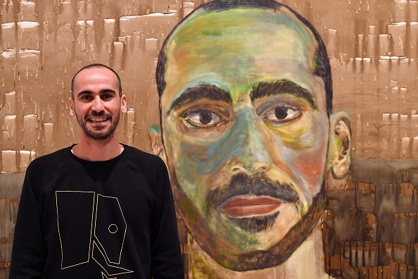 -L'artiste Mostafa Azimitabar devant son travail, intitulé "Self-Portrait", le travail des finalistes du prix Archibald est exposé à Sydney le 5 mai 2022. Photo SAEED KHAN/AFP via Getty Images.